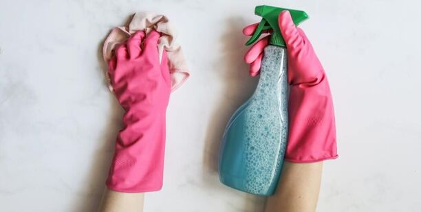Picture of hands scrubbing; gloves, cloth, spray bottle with cleaner